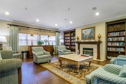 A living room with a fireplace and a bookshelf.